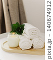 Minimalist still life of luxury spa essentials. White cotton towels with soy wax candle on a table. 140674912