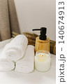 Minimalist still life of luxury spa essentials. White cotton towels, bottle with oli and candle on a table 140674913