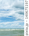 vertical poster with a sea view, wind and waves near the shore, time for windsurfing and active recreation during the summer vacation season 140675197