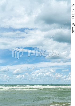 vertical poster with a sea view, wind and waves near the shore, time for windsurfing and active recreation during the summer vacation season 140675197