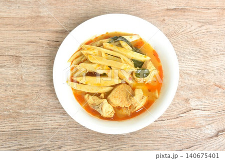 spicy boiled slice fresh bamboo shoot with pork in coconut milk Thai red curry soup on bowl spicy boiled slice fresh bamboo shoot with pork in coconut milk Thai red curry soup on bowl 140675401