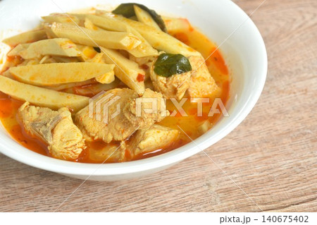 spicy boiled slice fresh bamboo shoot with pork in coconut milk Thai red curry soup on bowl spicy boiled slice fresh bamboo shoot with pork in coconut milk Thai red curry soup on bowl 140675402