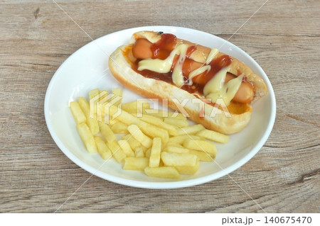 hot dog with cheese dressing ketchup and mayonnaise with French fried fast food on dish hot dog with cheese dressing ketchup and mayonnaise with French fried fast food on dish 140675470