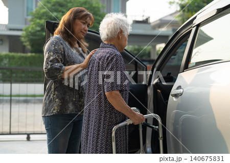 Caregiver help Asian elderly woman disability patient get in her car. Caregiver help Asian elderly woman disability patient get in her car. 140675831