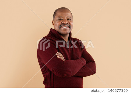 Confident mature African American man in maroon sweater with arms crossed 140677599