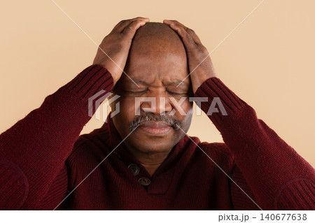 Mature black man with hands on head suffering from headache, eyes closed Mature black man with hands on head suffering from headache, eyes closed 140677638
