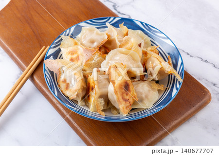 Golden pan-fried Chinese dumplings Jiaozi with premium sea cucumber and shrimp filling Golden pan-fried Chinese dumplings Jiaozi with premium sea cucumber and shrimp filling 140677707