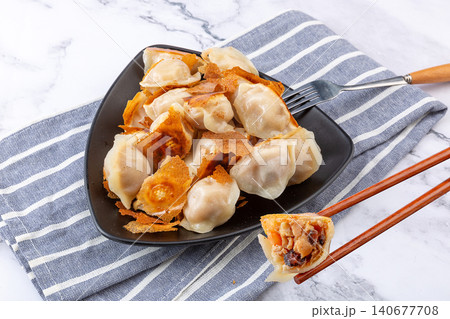 Golden pan-fried Chinese dumplings Jiaozi with premium sea cucumber and shrimp filling Golden pan-fried Chinese dumplings Jiaozi with premium sea cucumber and shrimp filling 140677708