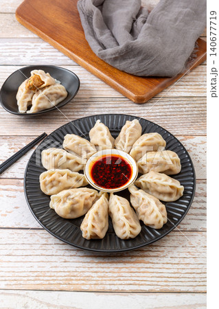 Freshly boiled Chinese pork and radish dumplings Jiaozi with spicy chili oil dipping sauce Freshly boiled Chinese pork and radish dumplings Jiaozi with spicy chili oil dipping sauce 140677719