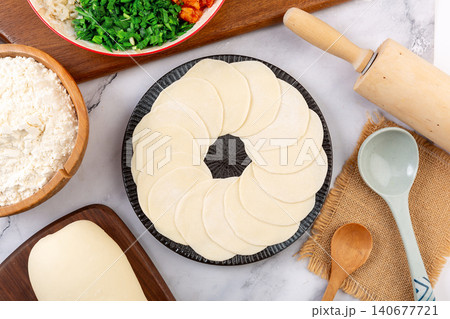 Round homemade Chinese dumpling wrappers arranged neatly on plate for making Jiaozi 140677721