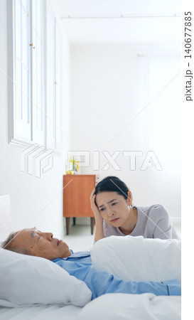 昏睡するシニア男性と悩む女性 140677885