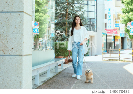 愛犬と街を散歩する笑顔の若い女性 愛犬と街を散歩する笑顔の若い女性 140678482
