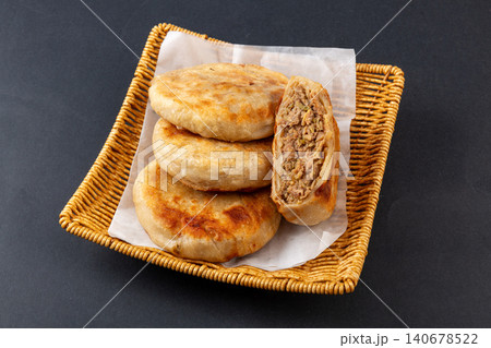 Golden crispy meat pies arranged inside a  bamboo steamer basket. 140678522