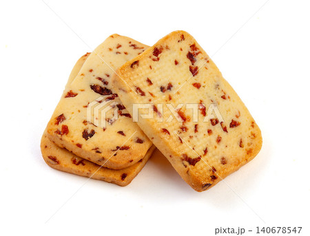 A heap of rectangular cranberry butter cookies with dried fruit bits scattered on a white background. A heap of rectangular cranberry butter cookies with dried fruit bits scattered on a white background. 140678547