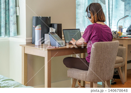 Concentrated learner utilizing technology in a comfortable home workspace 140678648
