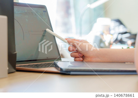 Focused student engaging in online learning with digital tablet and laptop at home for enhanced study experience 140678661