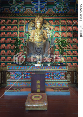 A golden statue of Guanyin Bodhisattva sits inside Chongqing millennium-old Luohan Temple. Behind the deity, hundreds of miniature alcoves form an intricate grid, This unique architecture defines the 140678945
