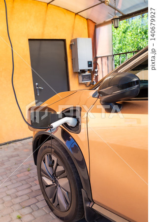 Close up of electric vehicle charging in driveway Close up of electric vehicle charging in driveway 140679927