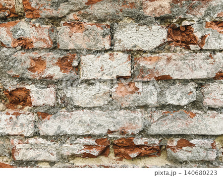 Close up of an old weathered brick wall with cracked plaster and exposed red bricks. Rustic grunge masonry texture background Close up of an old weathered brick wall with cracked plaster and exposed red bricks. Rustic grunge masonry texture background 140680223