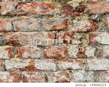 Close up of an old weathered brick wall with cracked plaster and exposed red bricks. Rustic grunge masonry texture background 140680224
