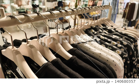Clothing hanging on rack in retail store, 140680357