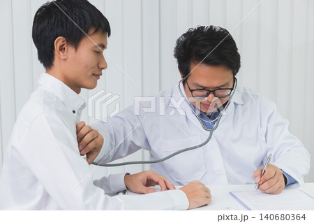 Doctor Checking Patient With Stethoscope. Doctor listening to patient chest with stethoscope in his office at the hospital. Doctor Checking Patient With Stethoscope. Doctor listening to patient chest with stethoscope in his office at the hospital. 140680364