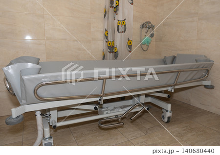 Medical hospital gurney with grey mattress and silver metal side rails in clean clinical setting. 140680440