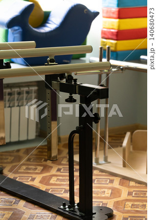 Black metal physical therapy equipment with adjustable bars and blue inflatable dolphin in clinic setting. 140680473