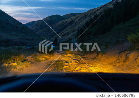 Driving on a Dirt Road in a Valley at Dusk 140680798