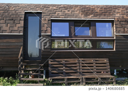 Wooden wall of rural cabin with large windows, 140680885