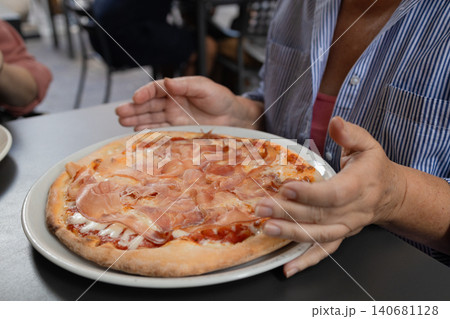 Happy young woman eating delicious Italian pizza at outdoor cafe in Europe Happy young woman eating delicious Italian pizza at outdoor cafe in Europe 140681128
