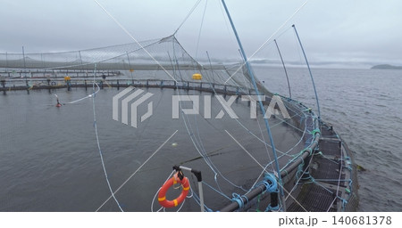 Large fish farm in the water with nets under cloudy sky as background 140681378