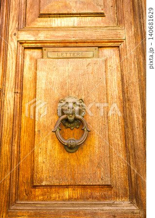 Vintage wooden door detail with antique bronze lion head door knocker and letter slot. Vintage wooden door detail with antique bronze lion head door knocker and letter slot. 140681629