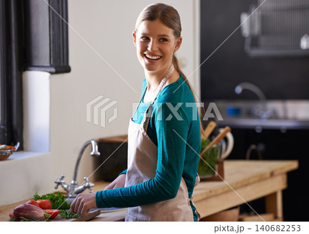 Happy, cooking and woman with vegetables in kitchen cutting ingredients with knife at home. Smile, groceries and young female person with produce for dinner, supper or meal at modern apartment. 140682253