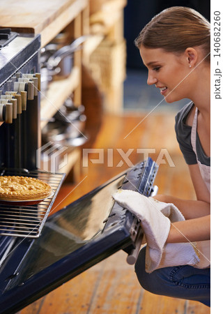 Bakery, oven and woman with a pie in kitchen and cooking as a chef at restaurant or cafe. Person, smile and baker prepare food in catering business with dinner or lunch and skill of baking pastry 140682260