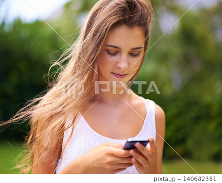 Phone, nature and young woman in park networking on social media, app or internet. Smile, technology and female person scroll on website with cellphone for communication in outdoor field or garden. 140682381