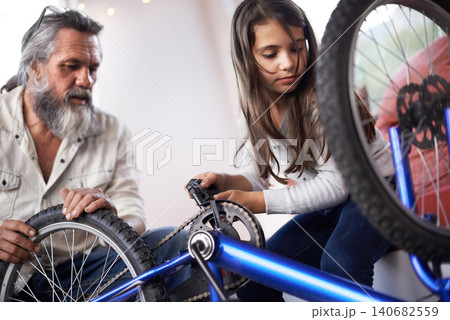 Father, child and bicycle for fixing chain as maintenance in garage for bonding together, transportation or teamwork. Mature man, daughter and equipment for bike repair or gear help, wheel or tyre Father, child and bicycle for fixing chain as maintenance in garage for bonding together, transportation or teamwork. Mature man, daughter and equipment for bike repair or gear help, wheel or tyre 140682559