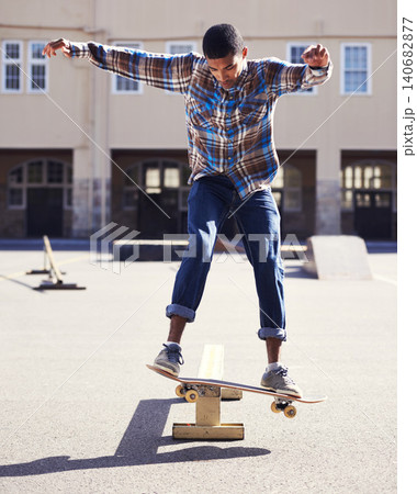 Man, skateboard and balance with riding at skatepark, sport and energy with skill, stunt and recreation outdoor. Skateboarder, technique and trick, action with training and workout for exercise 140682877
