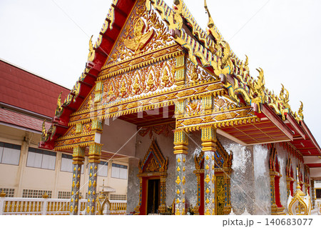 Ornate temple entrance with golden decoration, red roof, and carved gable in traditional asian shrine Ornate temple entrance with golden decoration, red roof, and carved gable in traditional asian shrine 140683077