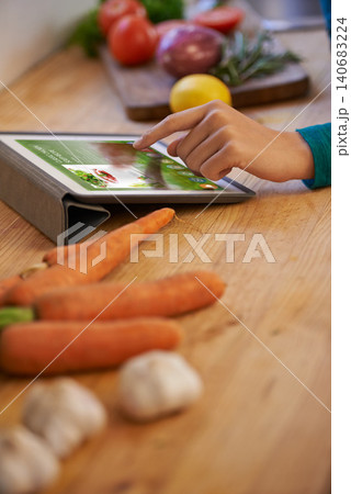 Hand, cooking and tablet with vegetables in kitchen as nutrition meal or online recipe, diet or connectivity. Person, home and raw ingredients with internet or vegan eating or prepare, dinner or chef Hand, cooking and tablet with vegetables in kitchen as nutrition meal or online recipe, diet or connectivity. Person, home and raw ingredients with internet or vegan eating or prepare, dinner or chef 140683224