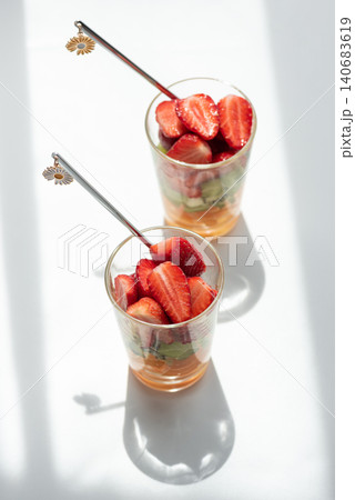 Two glasses of refreshing fruit salad preparing for consumption Two glasses of refreshing fruit salad preparing for consumption 140683619