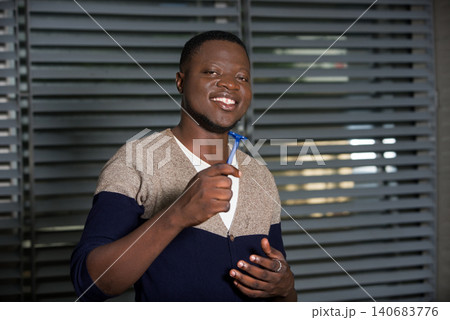 young man smiling with a razor. young man smiling with a razor. 140683776