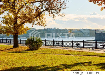 Isaac cathedral, Winter Palace, picturesque metal railings with a double-headed eagle and the crown of the Russian Empire on embankment in St. Petersburg, autumn sunset, incredible sun glare, Russia 140683916