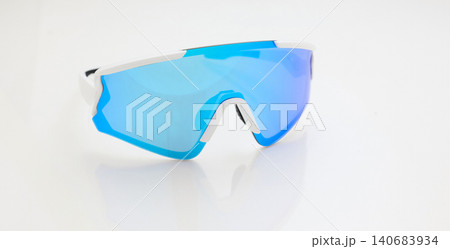 stylish sunglasses on a glossy white table, blue glass, white sunglasses frame, yachting glasses, cycling glasses, reflection on a glossy surface stylish sunglasses on a glossy white table, blue glass, white sunglasses frame, yachting glasses, cycling glasses, reflection on a glossy surface 140683934