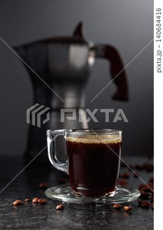Cup of espresso and classic Italian aluminium moka pot on a black background. Cup of espresso and classic Italian aluminium moka pot on a black background. 140684416