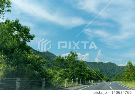 青空と緑の山々に続く高速道路の風景 140684769