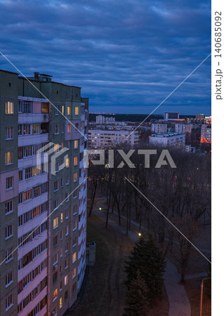 Dusk Minsk cityscape with Khrushchyovka block and lamplit park path 140685092