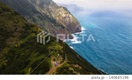 Aerial cliffs of Madeira with hikers and blue roof shelter visible Aerial cliffs of Madeira with hikers and blue roof shelter visible 140685196