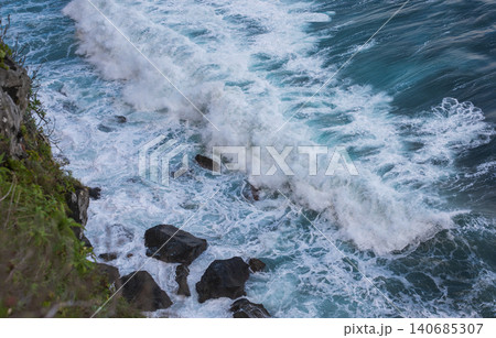 Atlantic surf pounds volcanic rocks on Madeira's rugged coastline 140685307