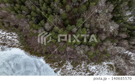 Aerial View of Snow Covered Forest and Frozen Water in Winter 140685570